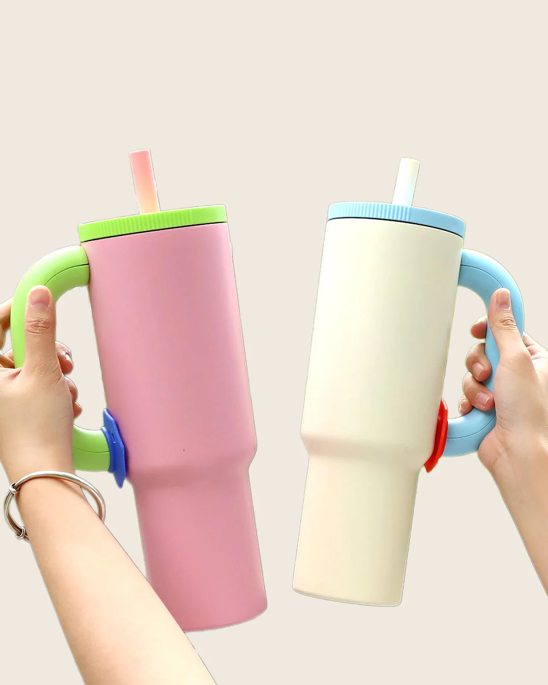 Colorful children's cups with handles and straws on a light blue background
