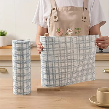 Person holding a checkered fabric basket with a cylindrical fabric roll on a wooden surface.