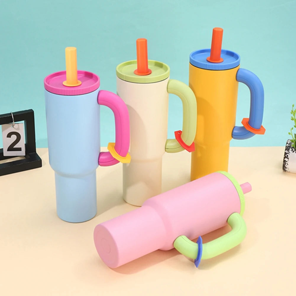 Colorful children's cups with handles and straws on a light blue background