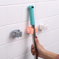 Mop handle with attachments on a tiled wall
