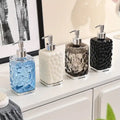 Set of four decorative soap dispensers on a bathroom counter.