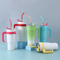 Set of colorful tumblers with handles and straws on a light blue background