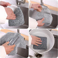 Gray scrubber being used to clean various kitchen items.