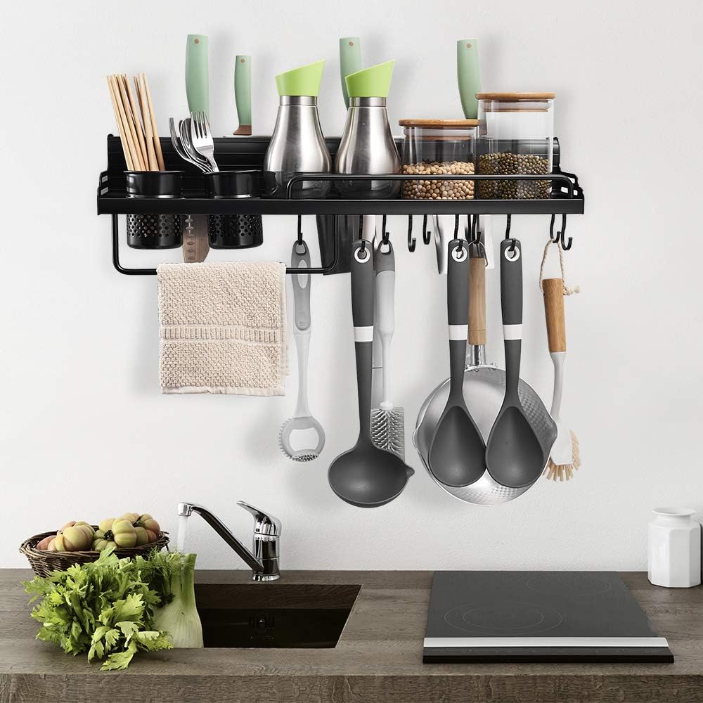 Kitchen utensil rack with various utensils hanging on a wall above a countertop.