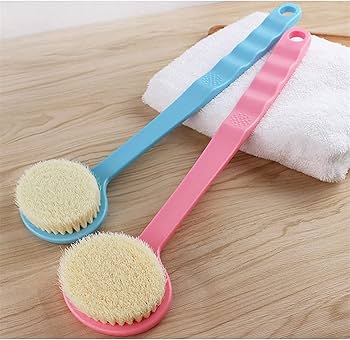 Two scrub brushes, one blue and one pink, with bristle heads on a wooden surface.
