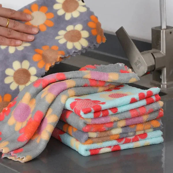 Stack of floral-patterned blankets on a green surface