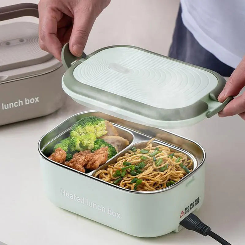 Heated lunch box with compartments filled with food, being held open by a person.