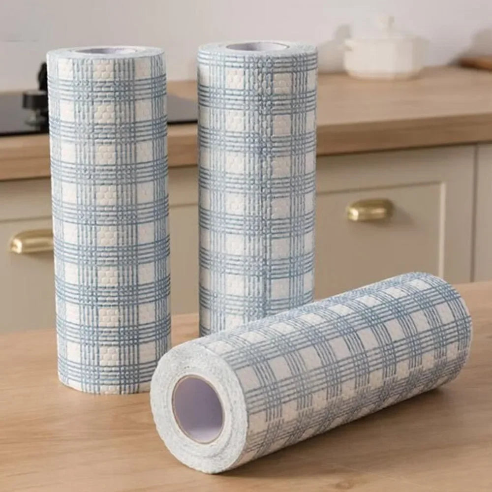 Three rolls of plaid-patterned tape on a wooden surface with a kitchen background.