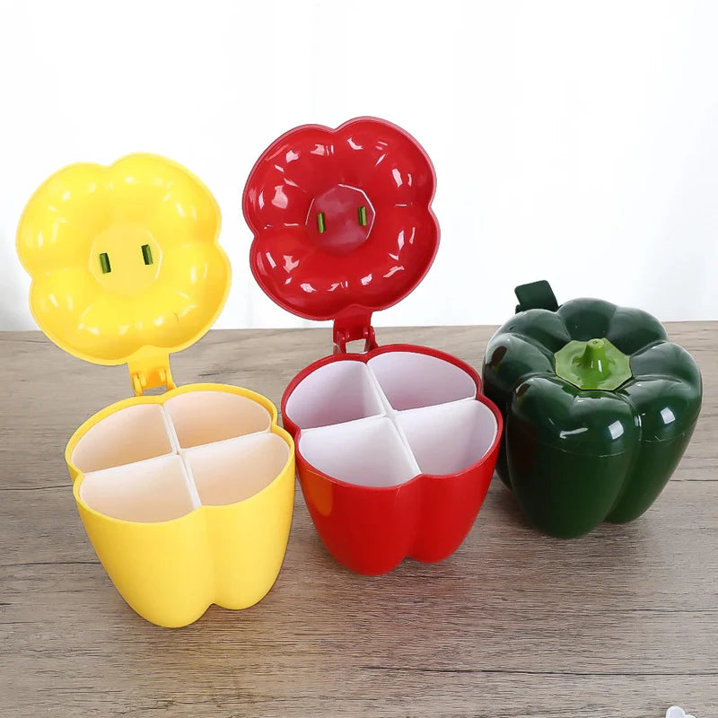 Colorful container shaped like a yellow flower, red bell pepper, and green bell pepper on a wooden surface.