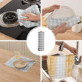 Multifunctional kitchen towel being used for cleaning various items in a kitchen setting.
