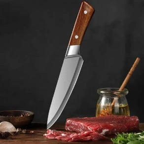 Knife with wooden handle on a dark background with raw meat and spices