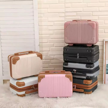 Set of suitcases in various colors stacked against a light-colored wall.
