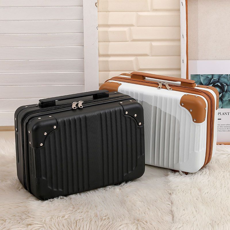 Set of suitcases in various colors stacked against a light-colored wall.
