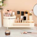 Makeup organizer with brushes, bottles, and a mirror on a light surface.