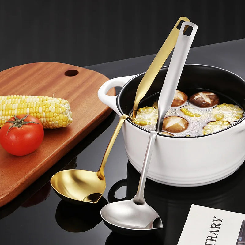 Bowl of soup with corn, carrots, and a ladle, surrounded by vegetables on a dark background