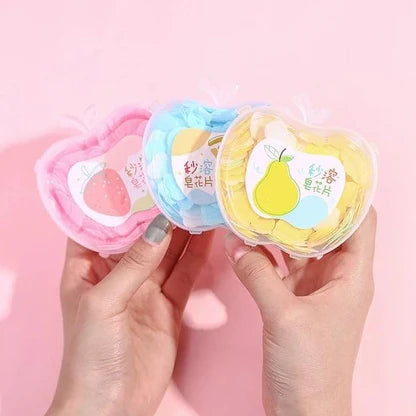 Set of colorful instant hand soaps in heart-shaped containers on a yellow surface.