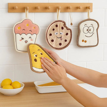 Four cartoon-themed pot holders hanging on a wooden rack with a hand reaching for one of them.