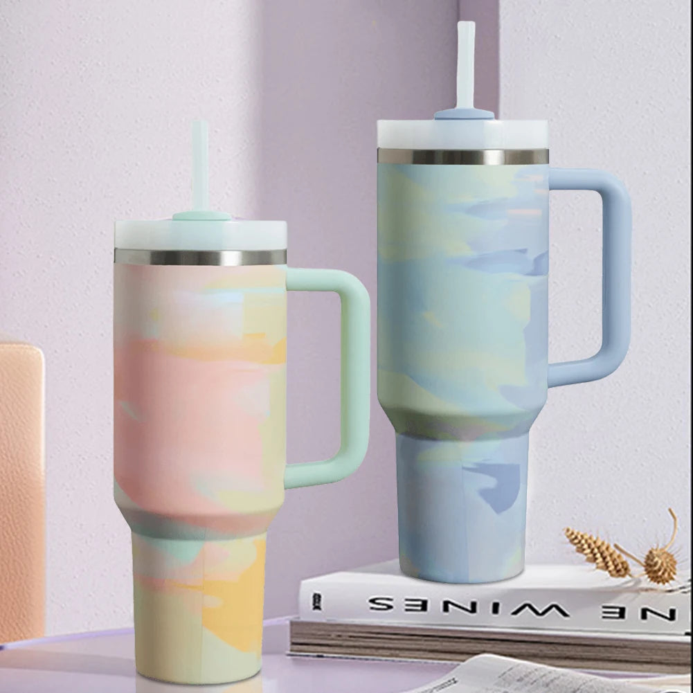 Two marbled pattern tumblers on a surface with a book and decorative items in the background.