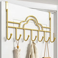 Gold over-the-door hook rack with clothes on a white door