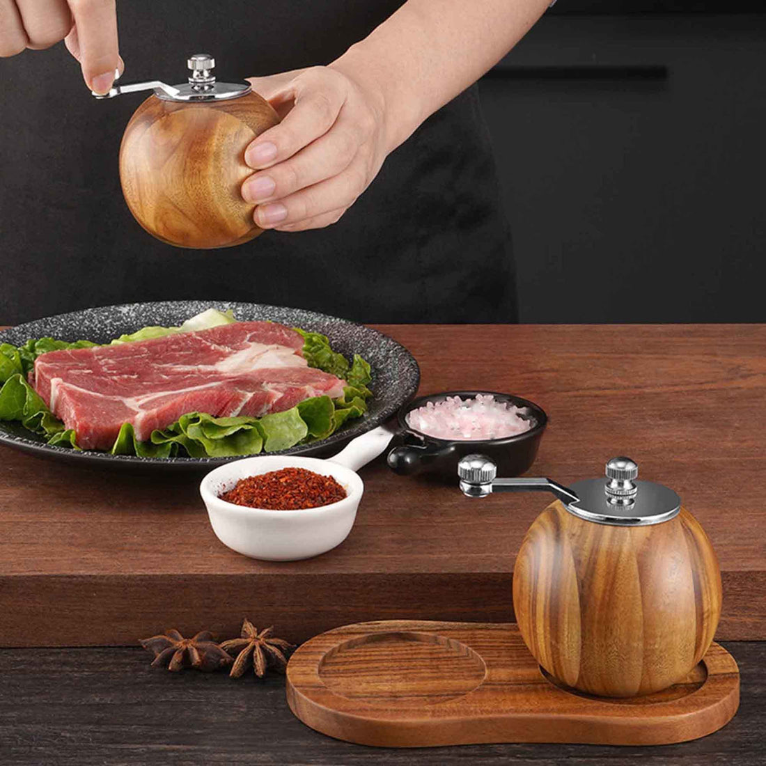 Person seasoning a dish with a wooden salt grinder on a black background