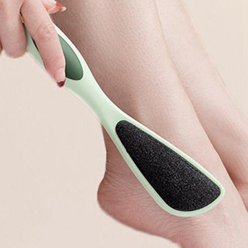 Person using a green and black foot scrubber on their leg.