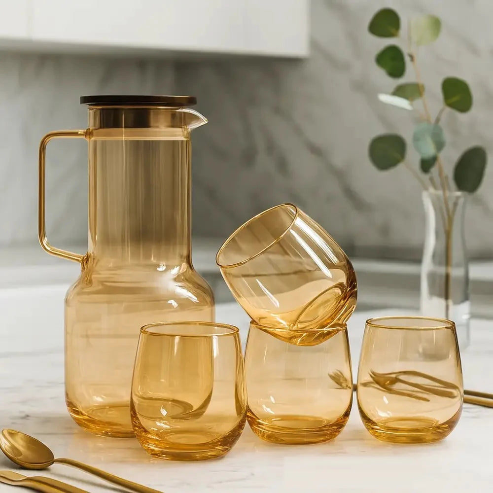 Set of amber glassware including a carafe and tumblers on a light surface.