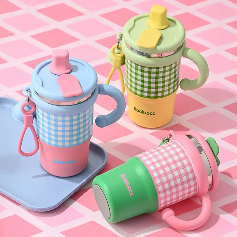 Three colorful children's sippy cups on a pink checkered background
