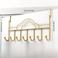 Gold over-the-door hook rack with measurements on a white door background