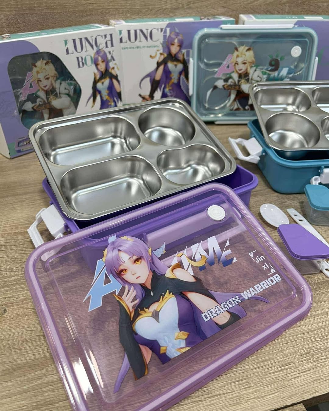 Anime-themed stainless steel lunch box with compartments on a wooden surface