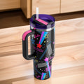 Travel mug with colorful designs on a wooden surface