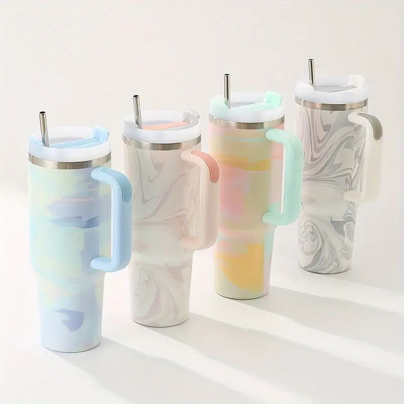 Two marbled pattern tumblers on a surface with a book and decorative items in the background.