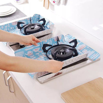 Person placing a portable gas stove on a blue mat with cartoon designs.