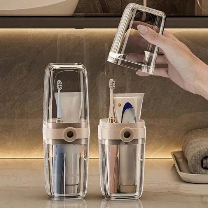 Clear toothbrush holder with toothbrushes and toothpaste on a bathroom counter.